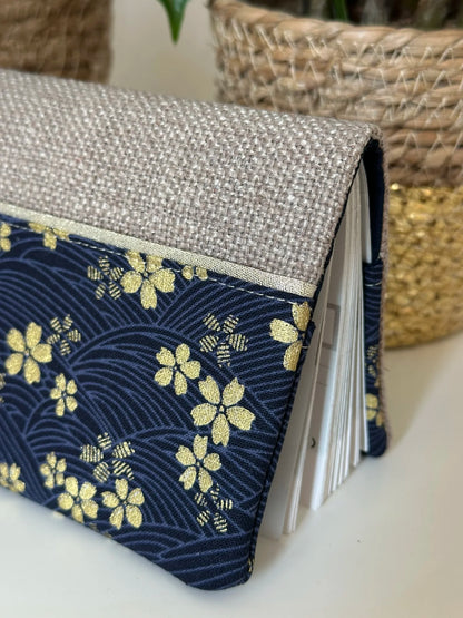 Les fleurs de cerisier dorées du porte chéquier en lin et tissu japonais Sakura bleu.