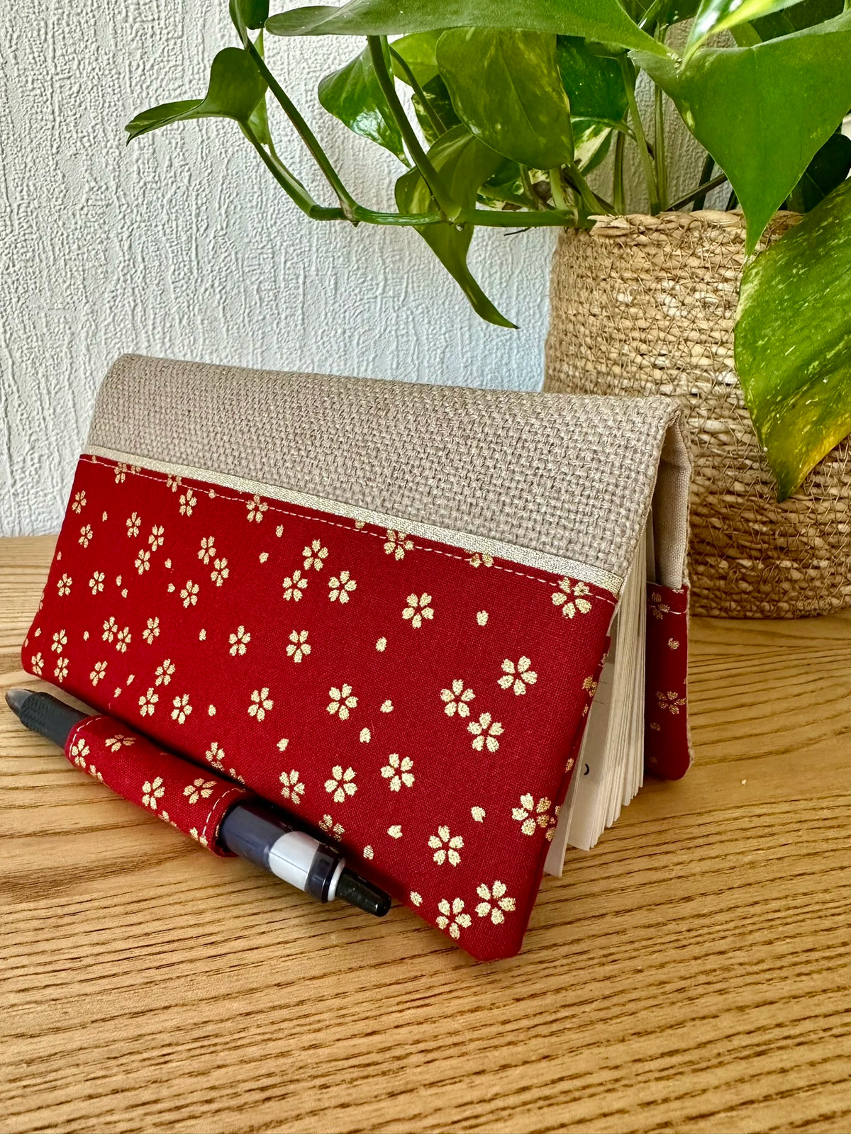 Vue latérale du porte chéquier avec porte stylo en lin et tissu japonais Sakura rouge.