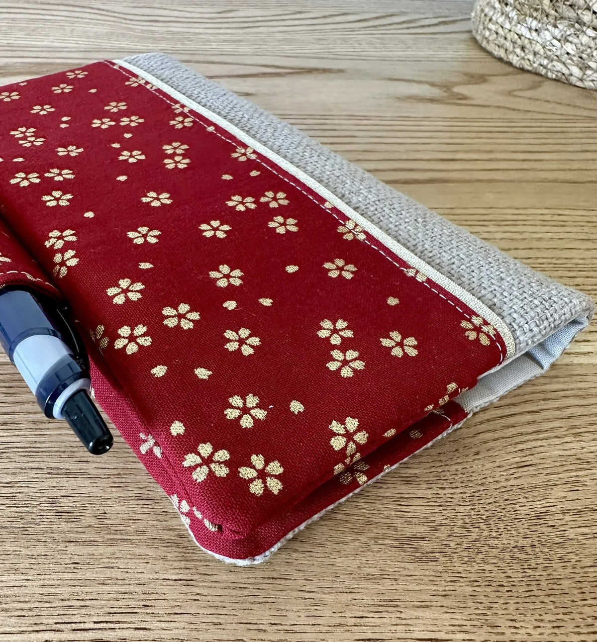 Vue détaillée du porte chéquier avec porte stylo en lin et tissu japonais Sakura rouge.