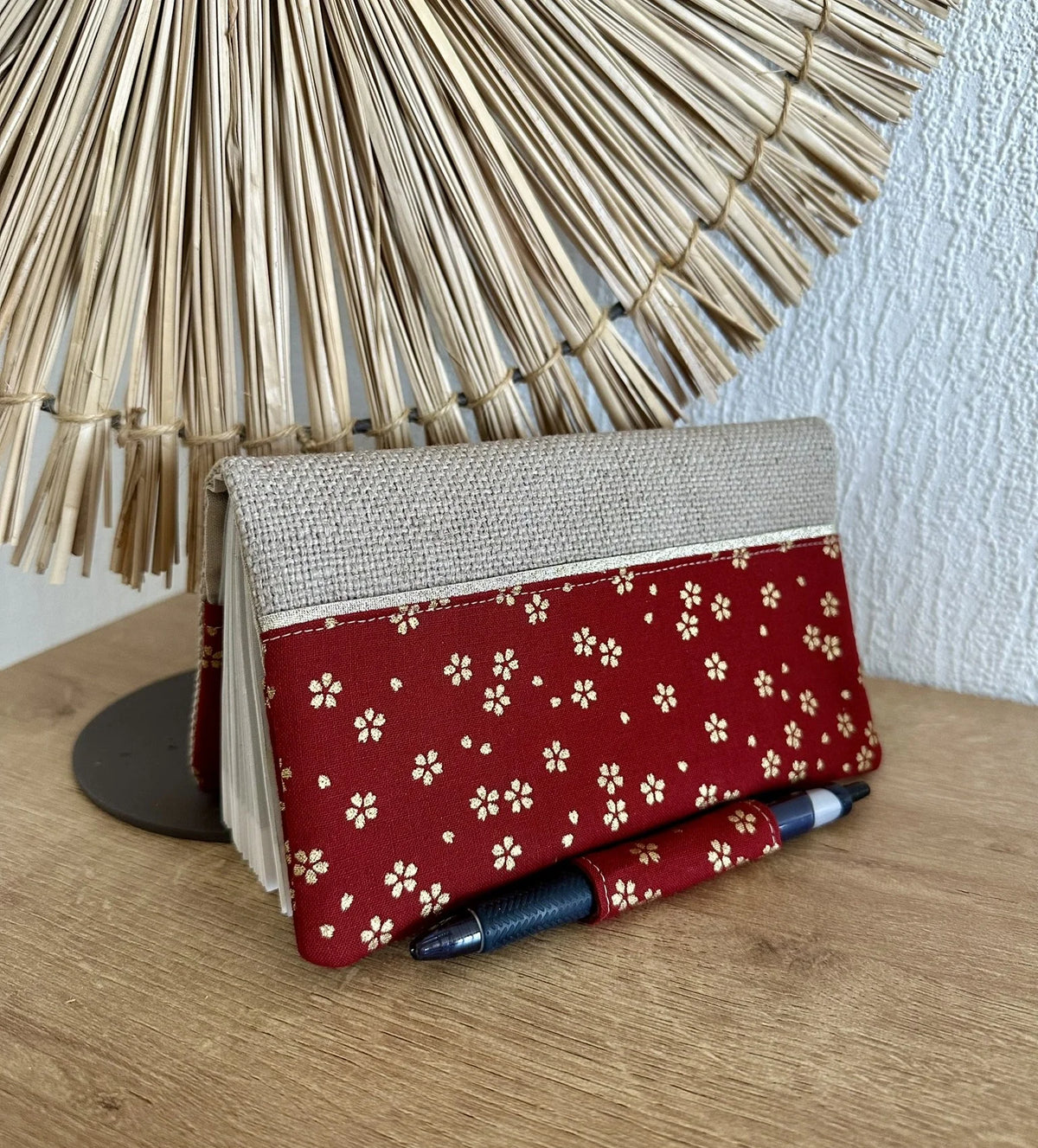 Face avant du porte chéquier avec porte stylo en lin et tissu japonais Sakura rouge.