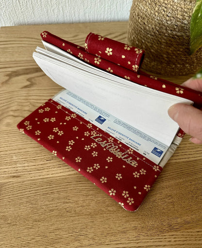 Le rabat inférieur du porte chéquier avec porte stylo en lin et tissu japonais Sakura rouge.