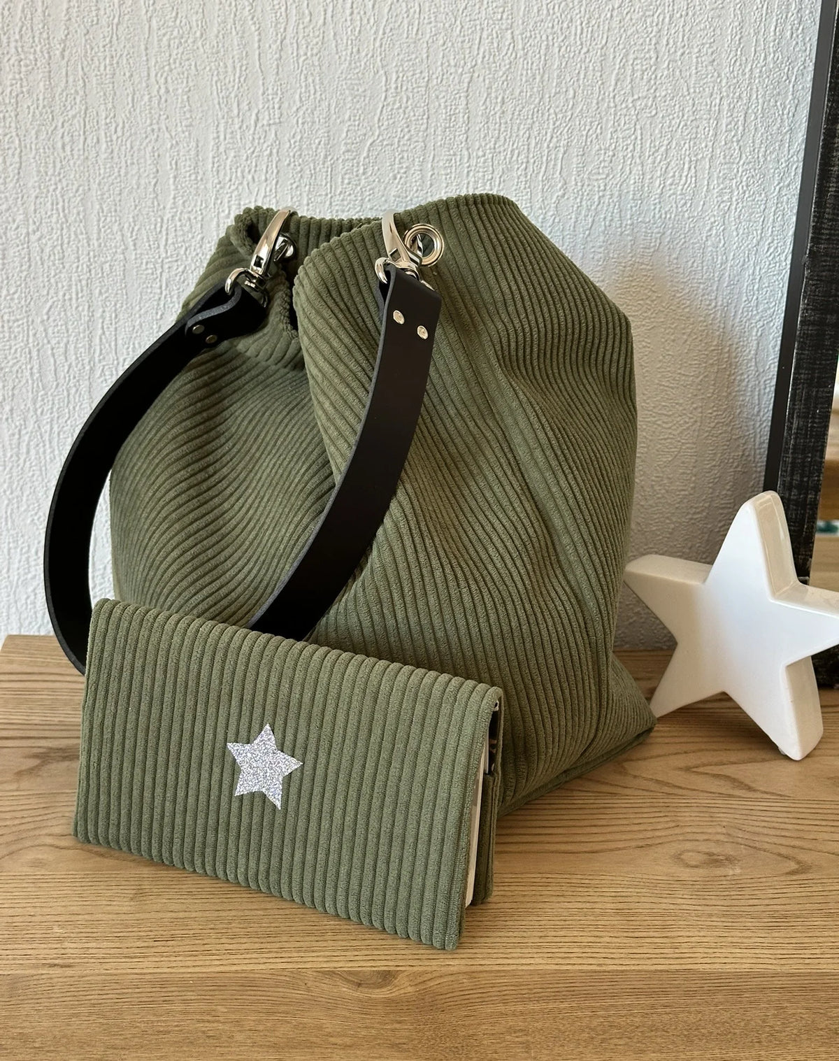 Le porte chéquier en velours vert armée et son étoile pailletée argentée avec le sac Hobo en velours vert armée.