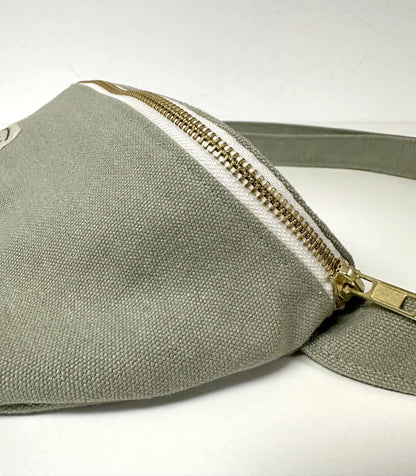 Vue de détail du sac banane en toile vert amande.