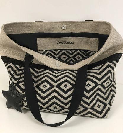 La poche zippée intérieure du sac cabas Isa en lin et chevrons noirs à paillettes.