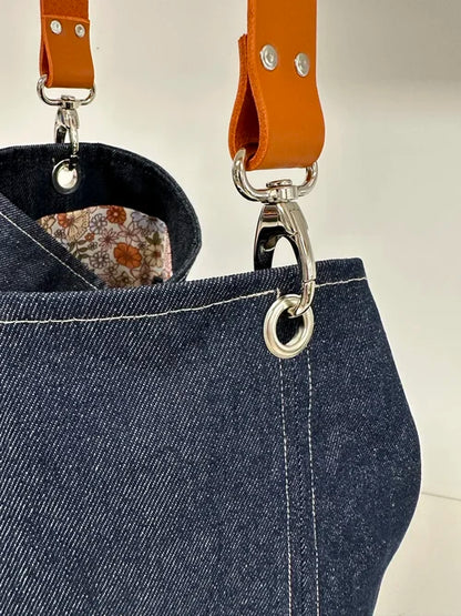 Le mousqueton du sac hobo en denim et son anse en cuir orange 