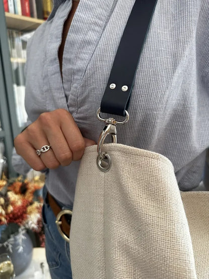 L'anse en cuir du sac Hobo en lin ivoire et anse amovible en cuir bleu.