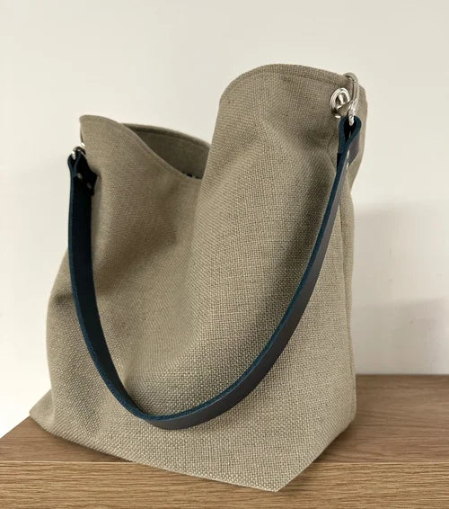 Vue d'ensemble du sac Hobo en lin beige et son anse en cuir bleu marine 