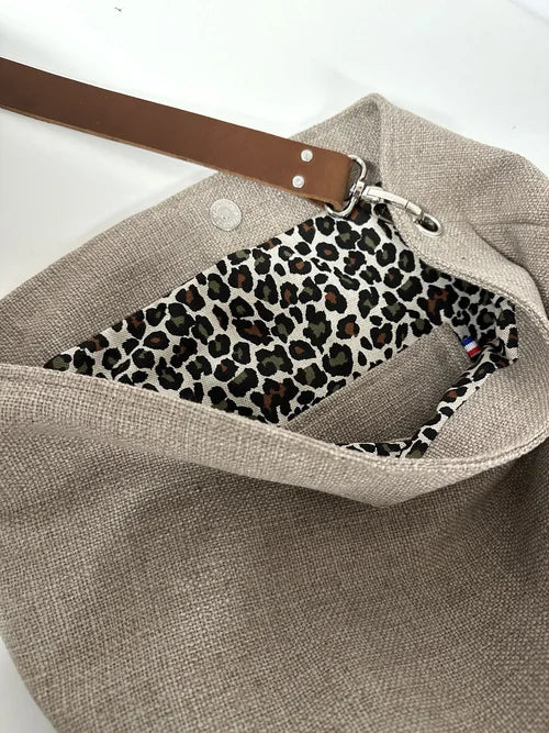 La poche plaquée intérieure du sac Hobo en lin beige et léopard avec anse en cuir marron