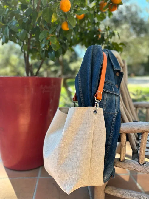 Le sac Hobo en lin ivoire et son anse en cuir orange
