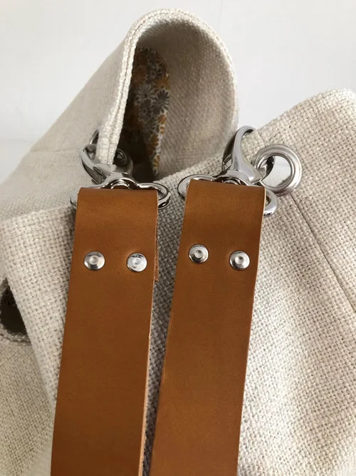 Les mousquetons accrochés au sac Hobo en lin ivoire et anse en cuir fauve