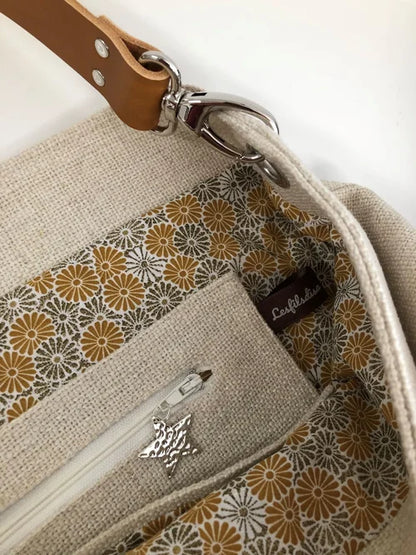 La poche intérieure zippée du sac Hobo en lin ivoire et anse en cuir fauve