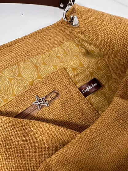 la poche intérieure zippée du sac Hobo en lin moutarde et son anse en cuir marron