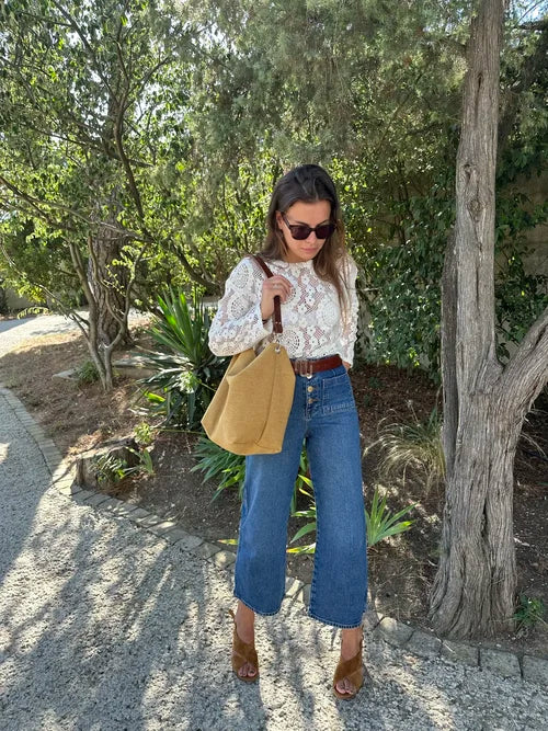 femme portant à l'épaule le sac Hobo en lin moutarde et son anse en cuir marron