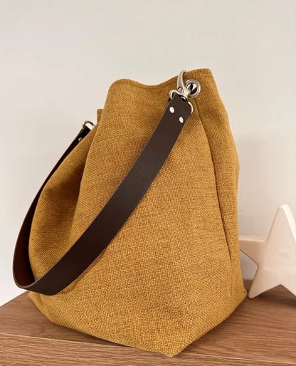 Le sac Hobo en lin moutarde et son anse en cuir marron
