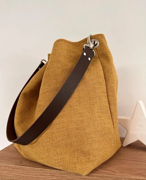 Le sac Hobo en lin moutarde et son anse en cuir marron