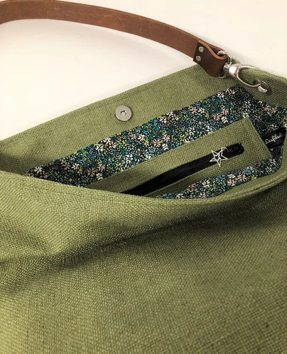 La poche intérieure zippée du sac hobo en lin vert kaki et son anse en cuir marron amovible