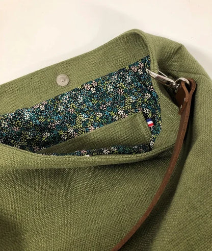 La poche plaquée intérieure du sac hobo en lin vert kaki et son anse en cuir marron amovible