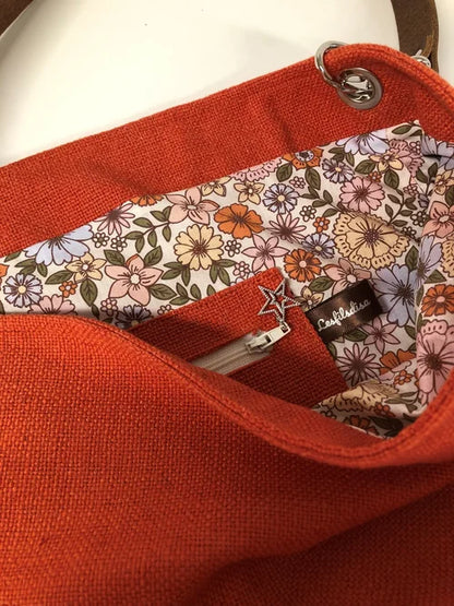 La poche intérieure zippée du sac Hobo en lin orangé et son anse en cuir marron amovible