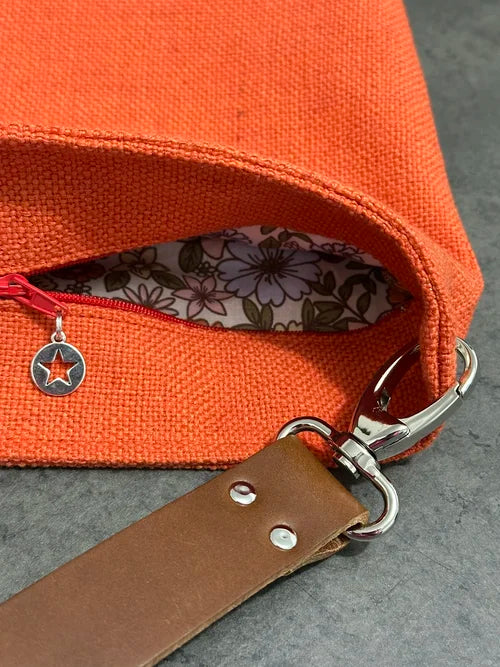 le sac Hobo en lin orangé et son anse en cuir marron amovible et fermeture éclair