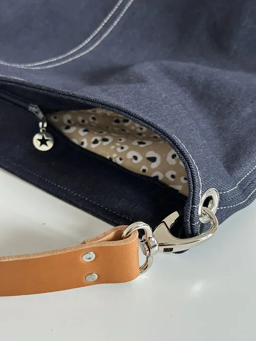 Le sac hobo en toile denim brut avec fermeture éclair