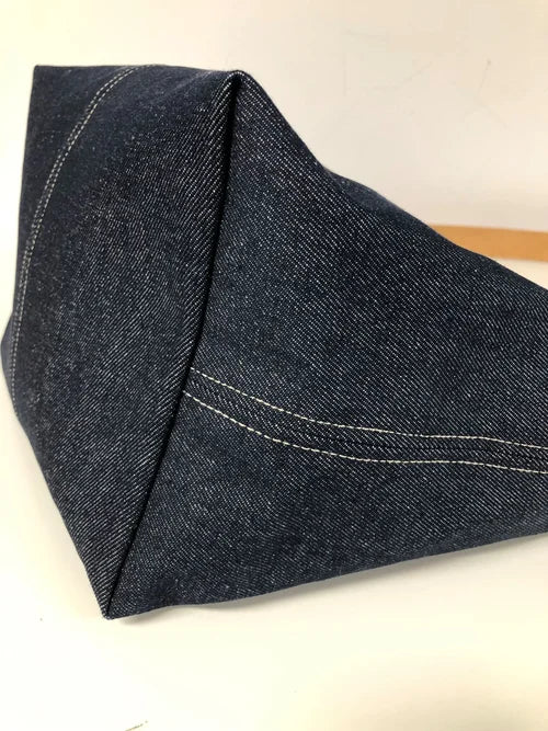 Le fond du sac hobo en toile denim brut et son anse en cuir fauve