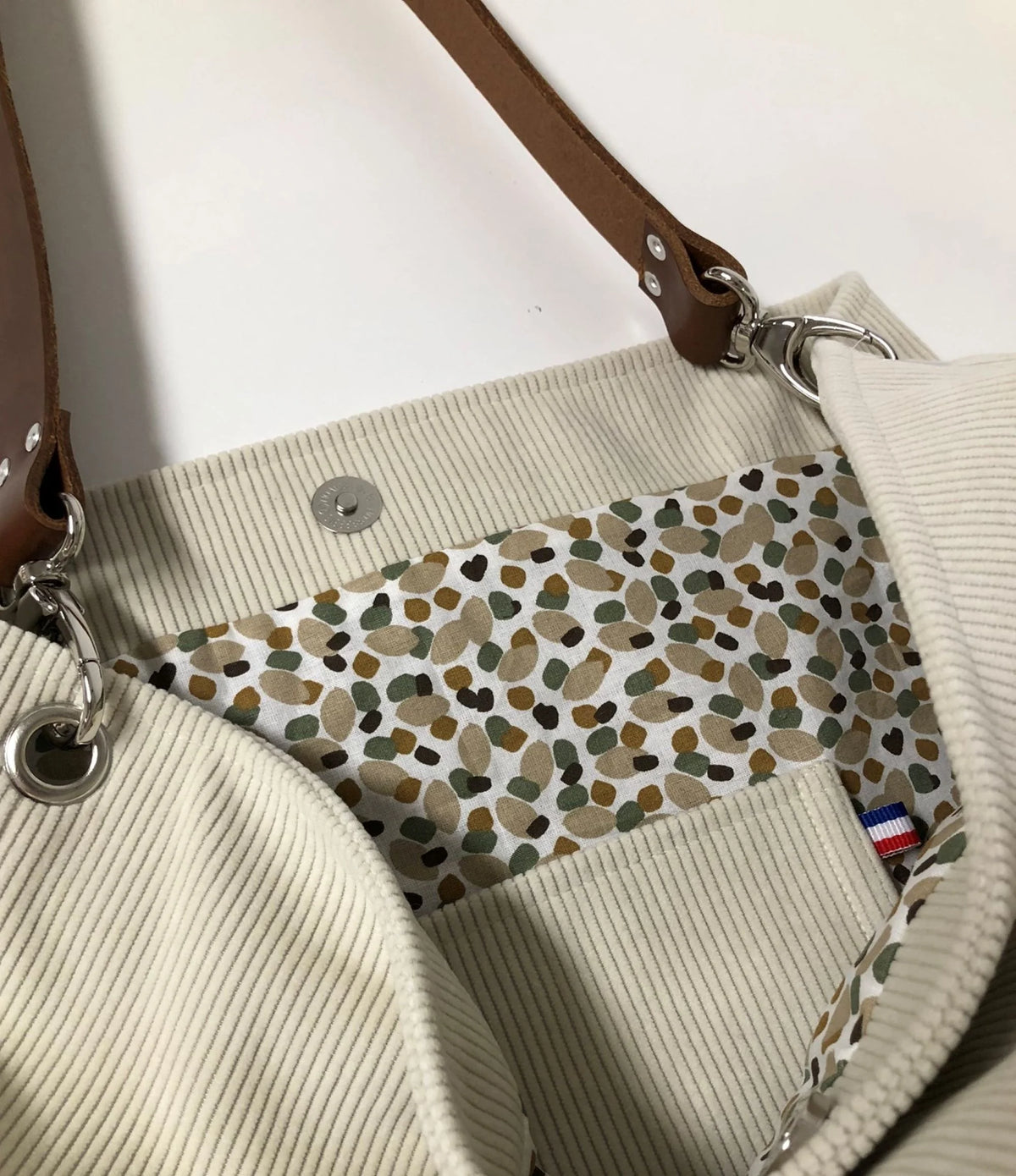 La deuxième poche intérieure du sac hobo en velours cotelé ivoire et son anse en cuir.