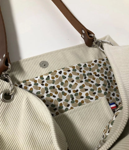 La deuxième poche intérieure du sac hobo en velours cotelé ivoire et son anse en cuir.