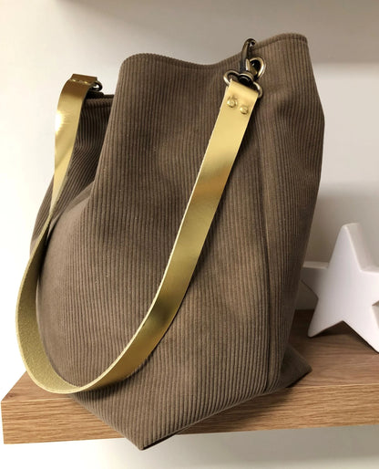 Le sac hobo en velours cotelé marron chamois et son anse en cuir doré