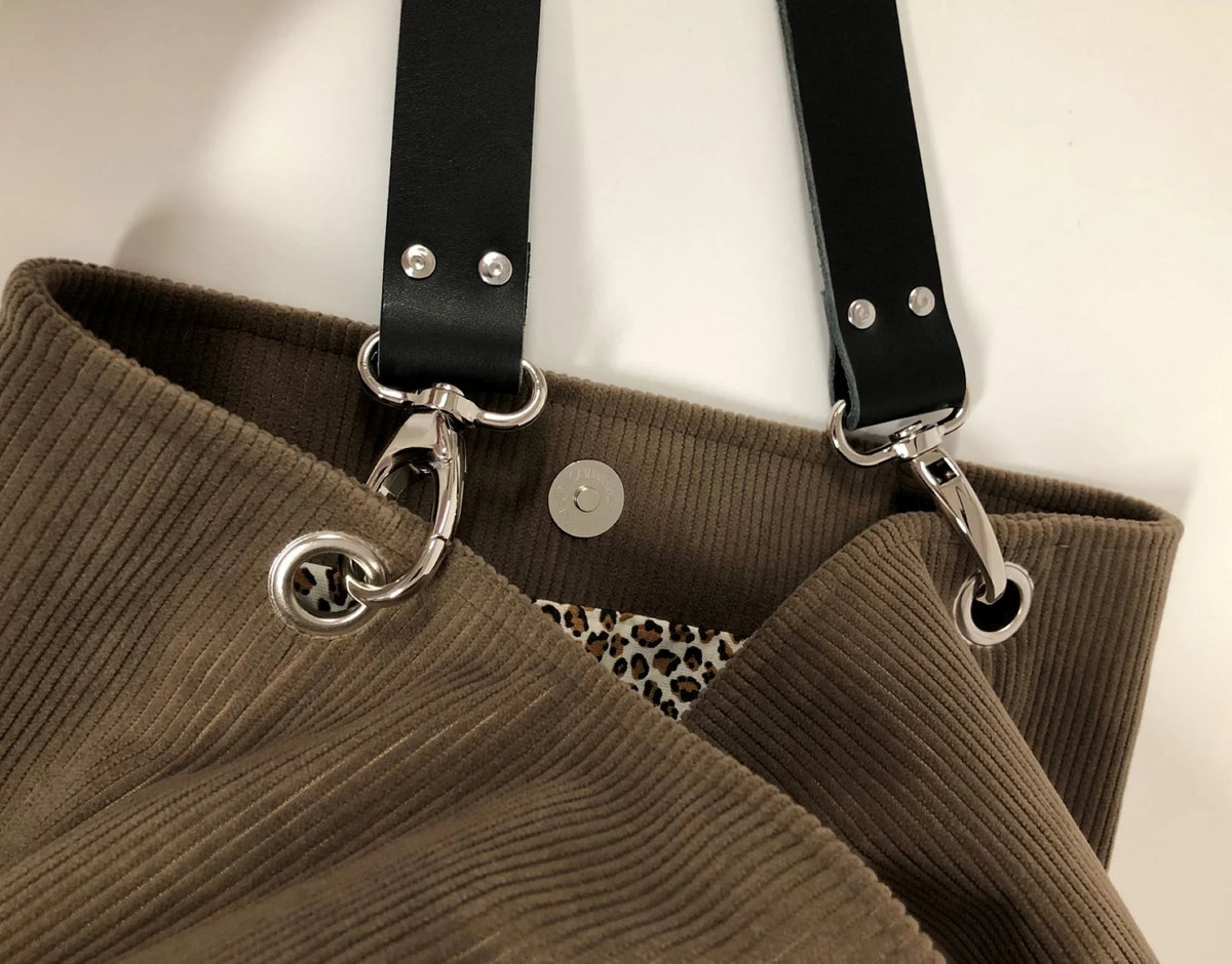 L'anse en cuir amovible du sac hobo en velours cotelé marron chamois .