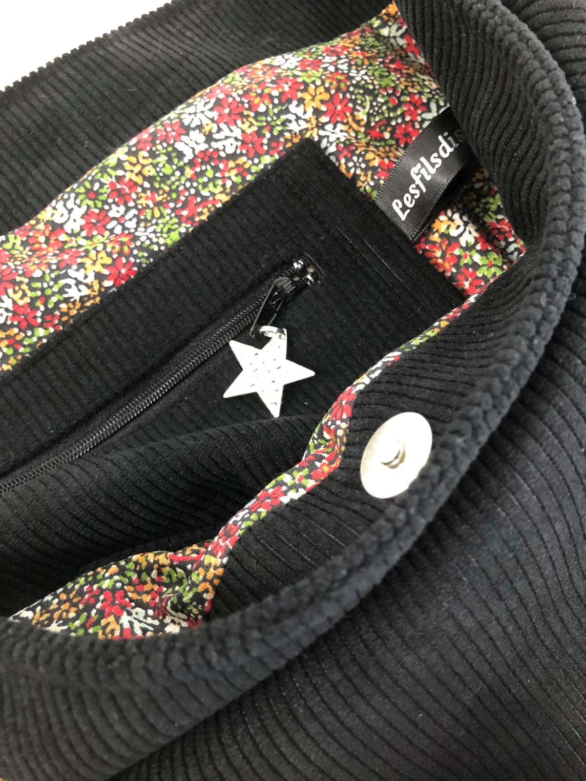 La poche zippée intérieure du sac hobo en velours cotelé noir et son anse en cuir.