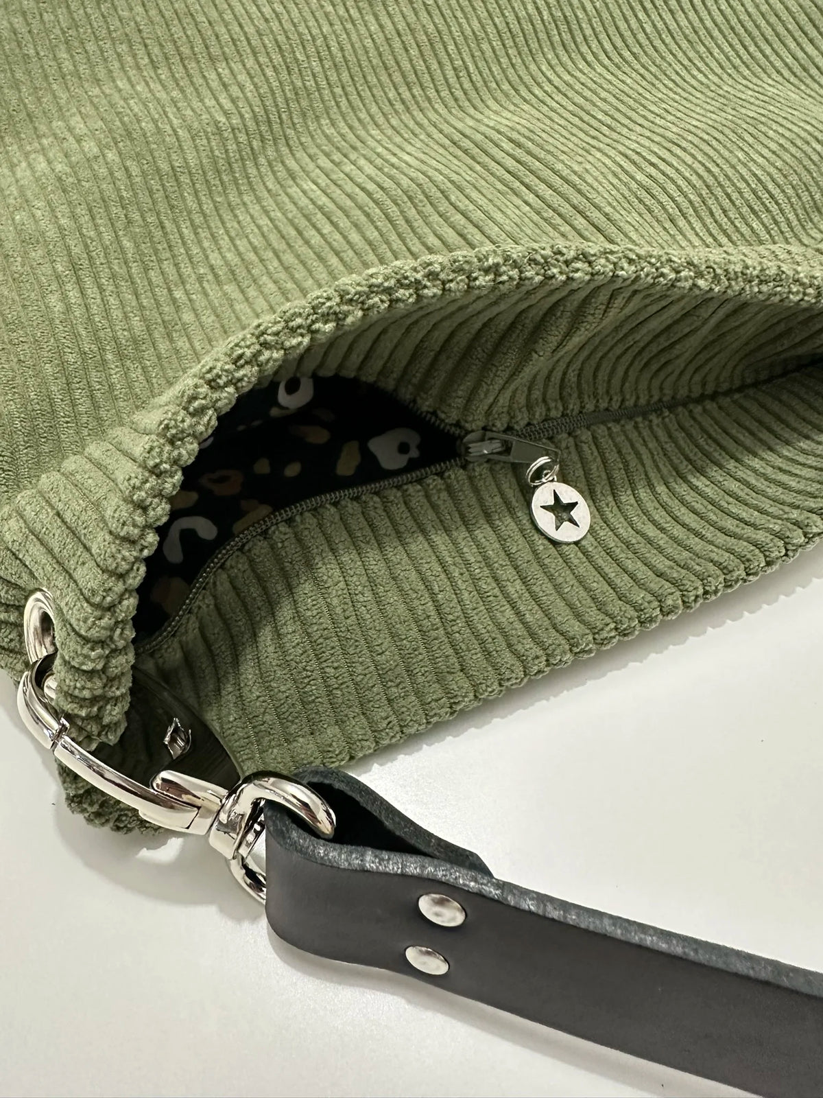 Le sac Hobo en velours cotelé vert armée avec fermeture éclair.