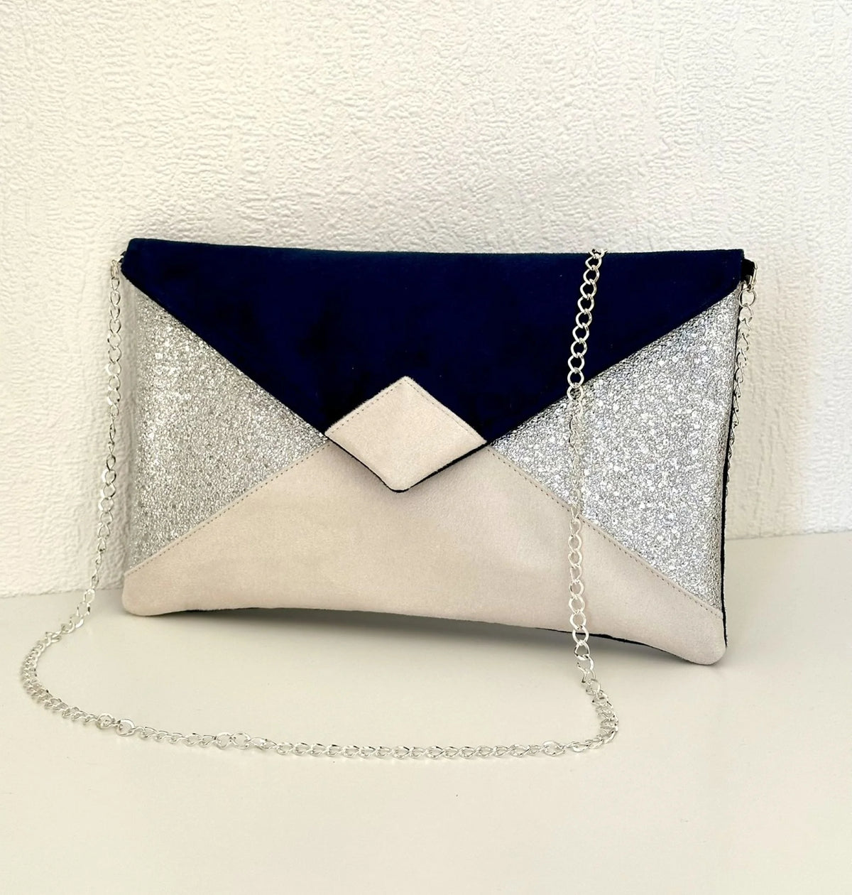 Face avant du sac pochette Isa bleu marine, ivoire et argenté.