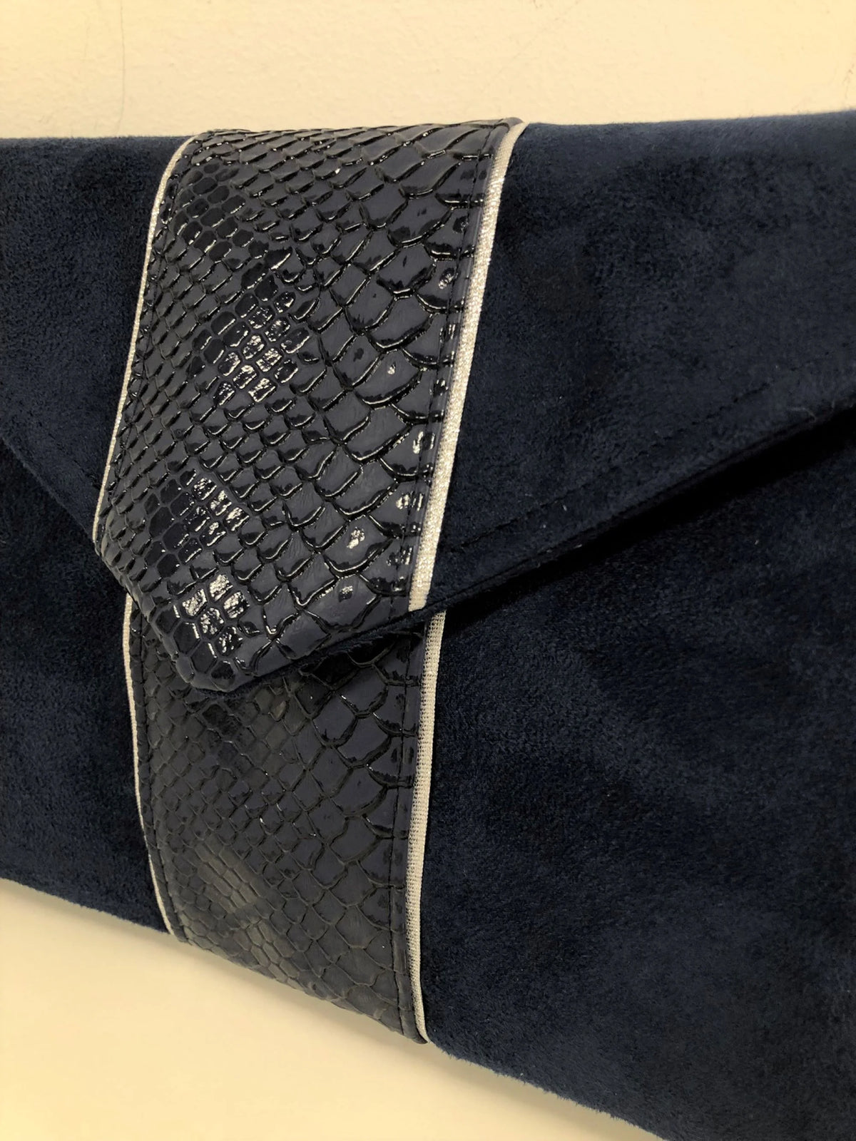 Vue détaillée du sac pochette Isa bleu marine reptile à liseré argenté.
