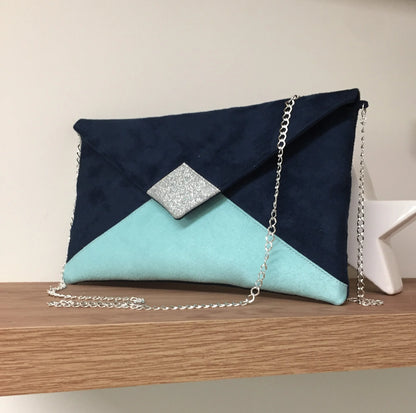 Le sac pochette Isa bleu marine et vert menthe à paillettes argentées, avec chainette amovible.
