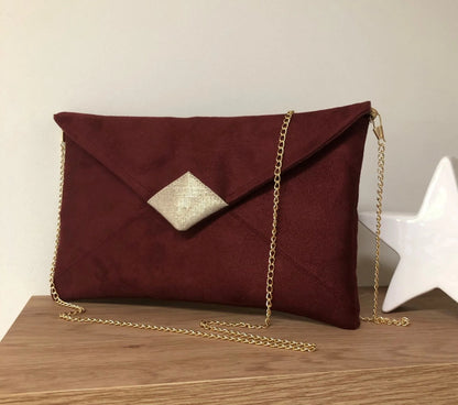 Le sac pochette Isa bordeaux et lin doré, avec chainette amovible, vue de face.