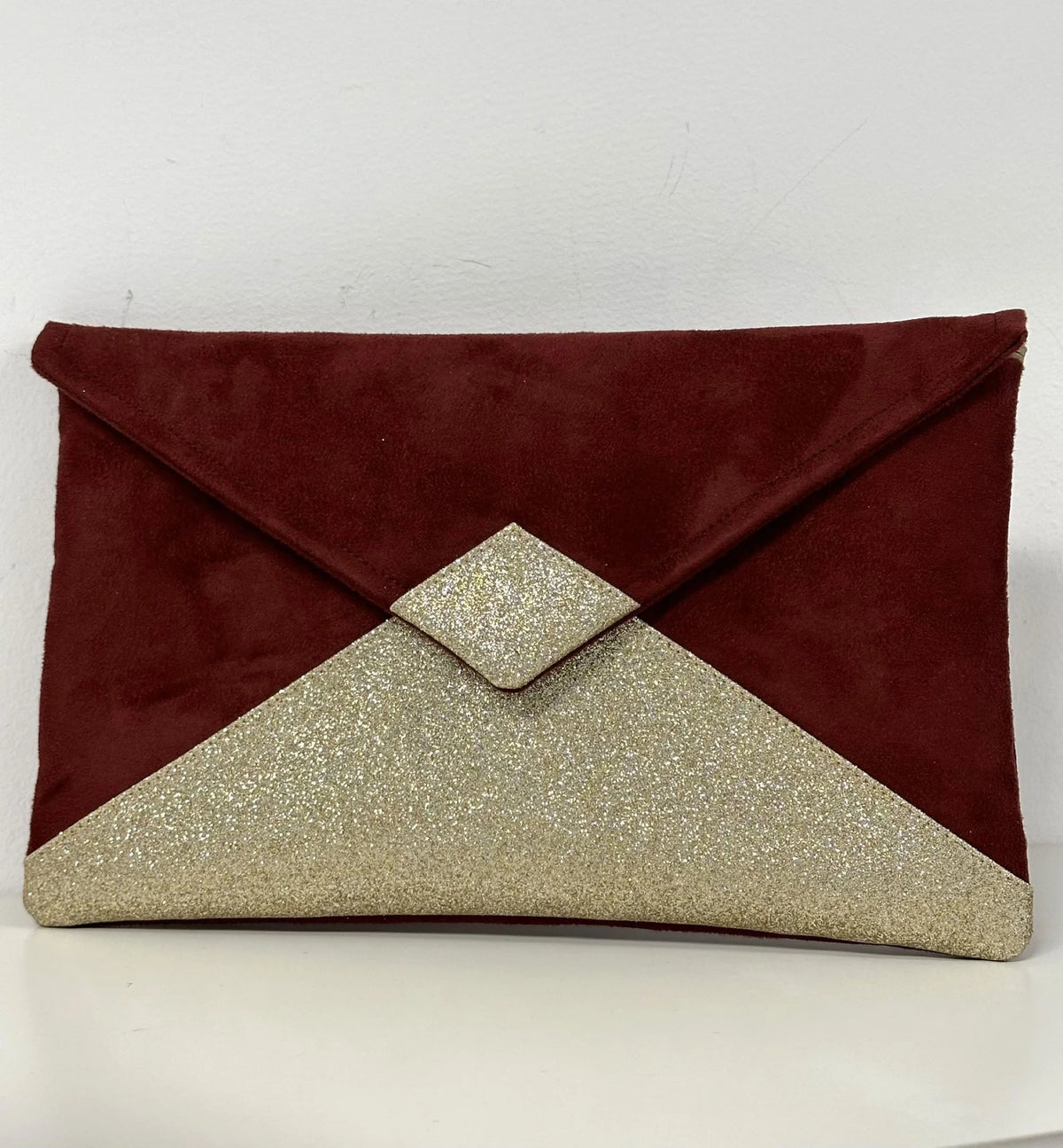 Le sac pochette Isa bordeaux à paillettes dorées, sans chainette.
