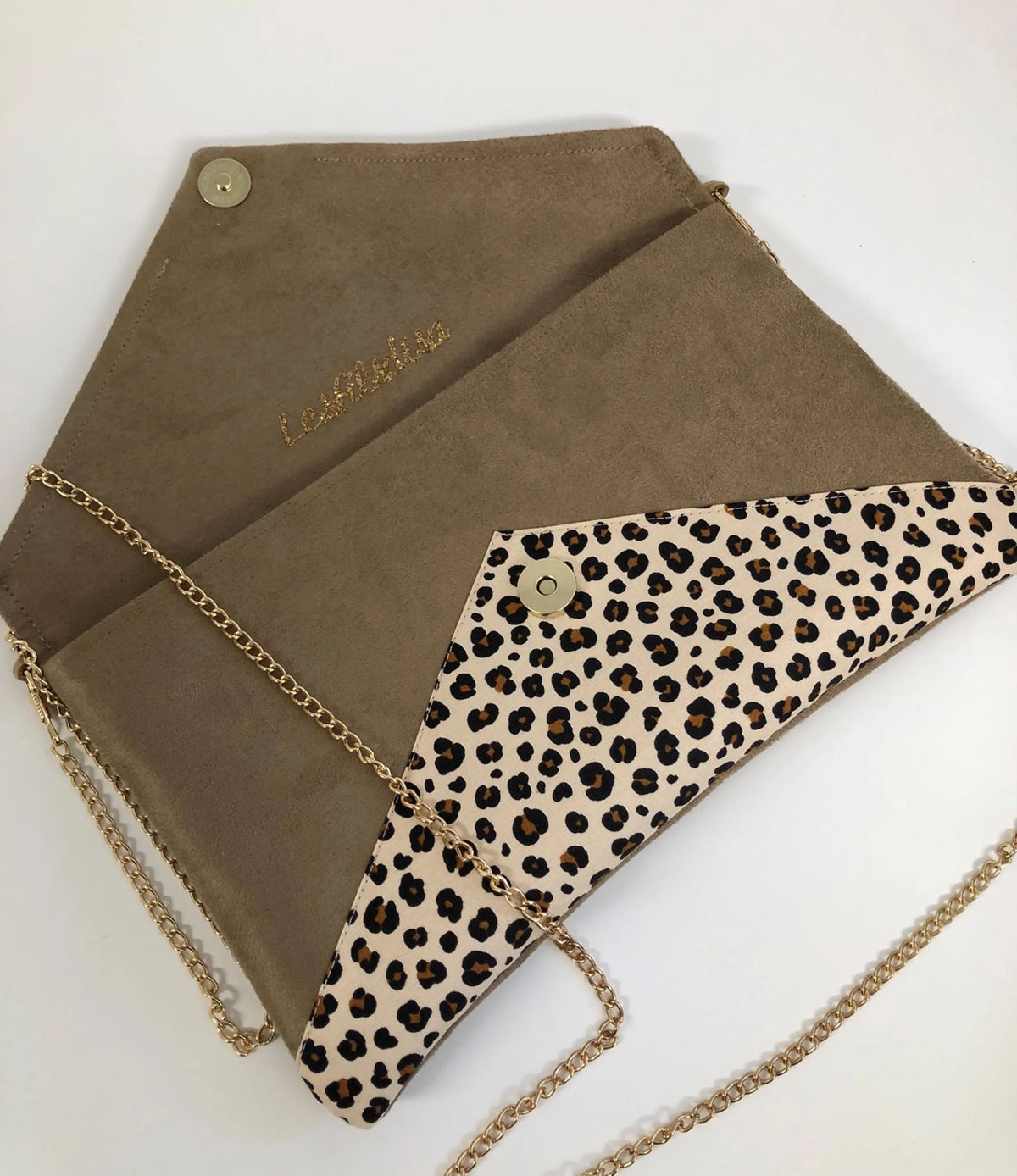 Le sac pochette Isa camel à motif animal et paillettes dorées, avec sa chainette amovible, ouvert.