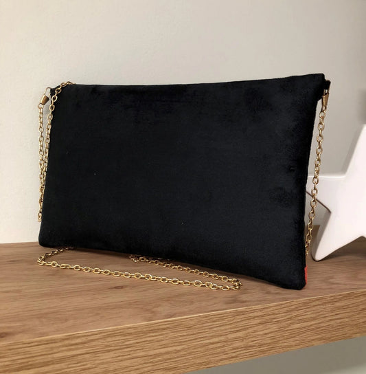 Face arrière du sac pochette Isa noir et corail à paillettes dorées.
