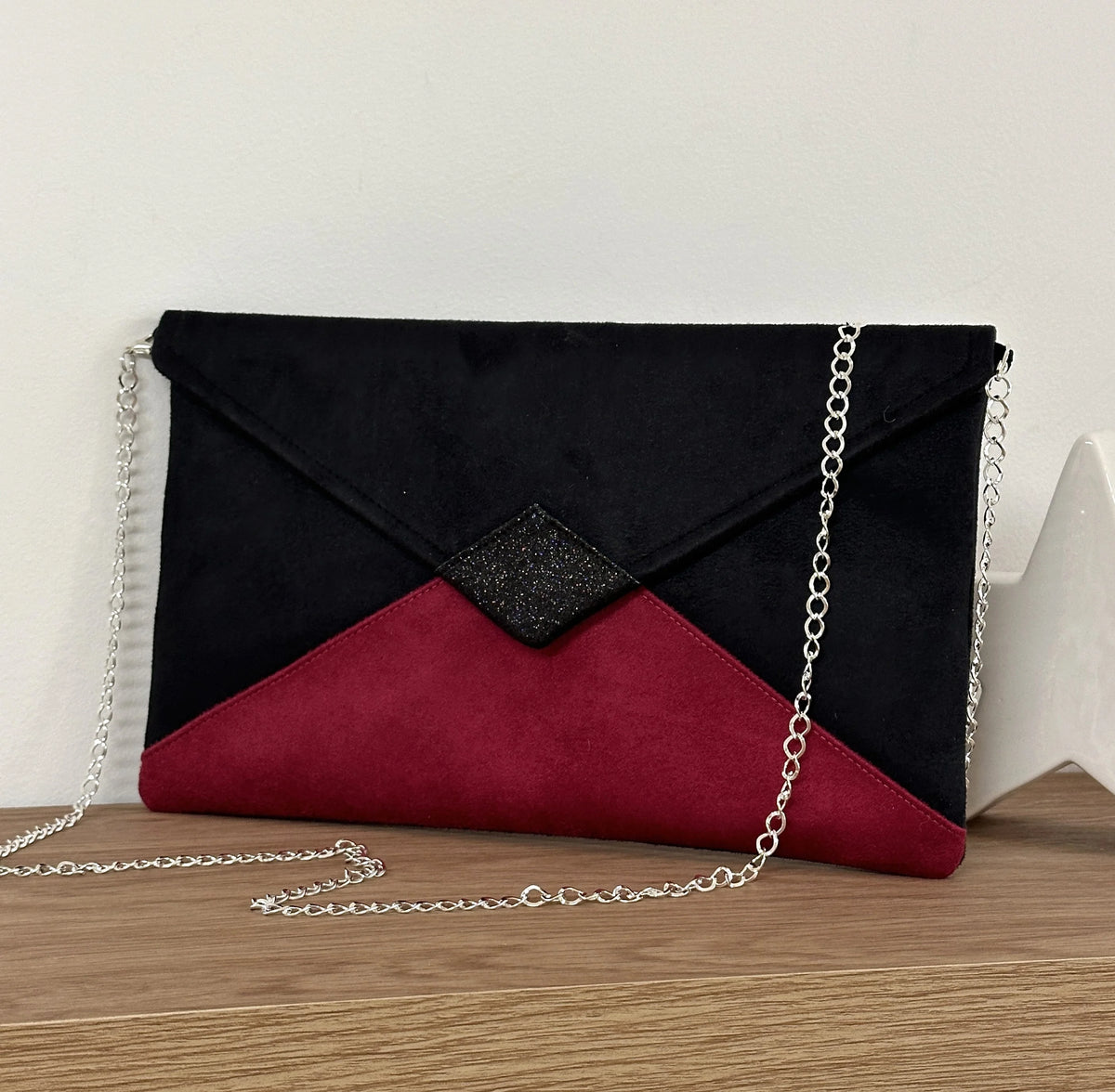 Le sac pochette Isa noir et fuchsia à paillettes  avec chainette argentée amovible.