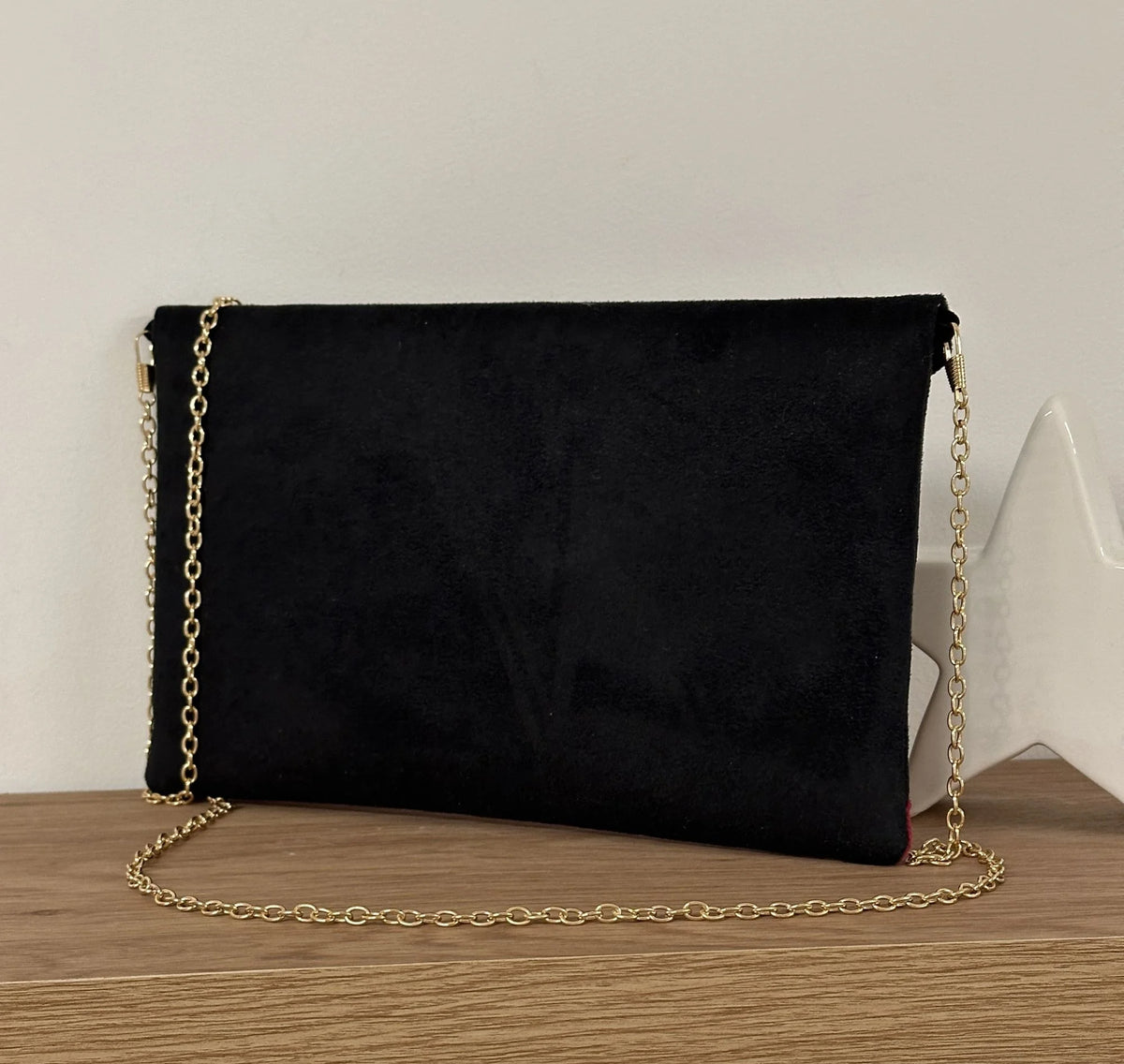 Vue arrière du sac pochette Isa noir et fuchsia à paillettes .