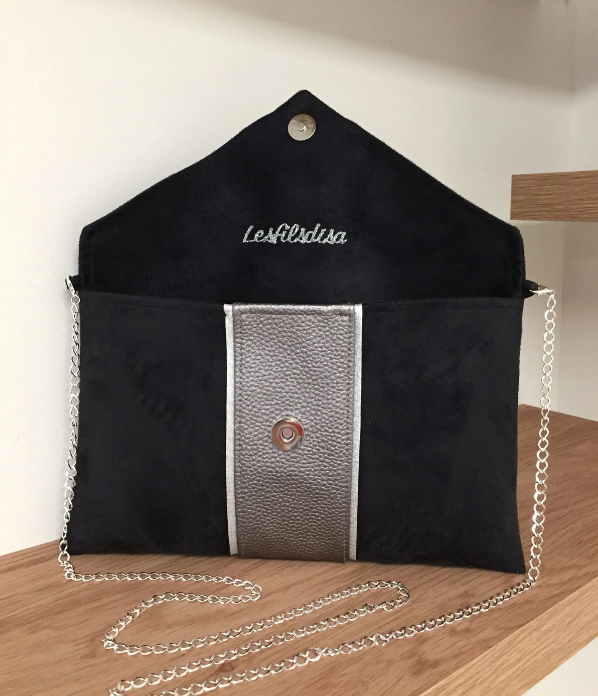 Le  sac pochette Isa noir et gris irisé à liseré argenté, ouvert.