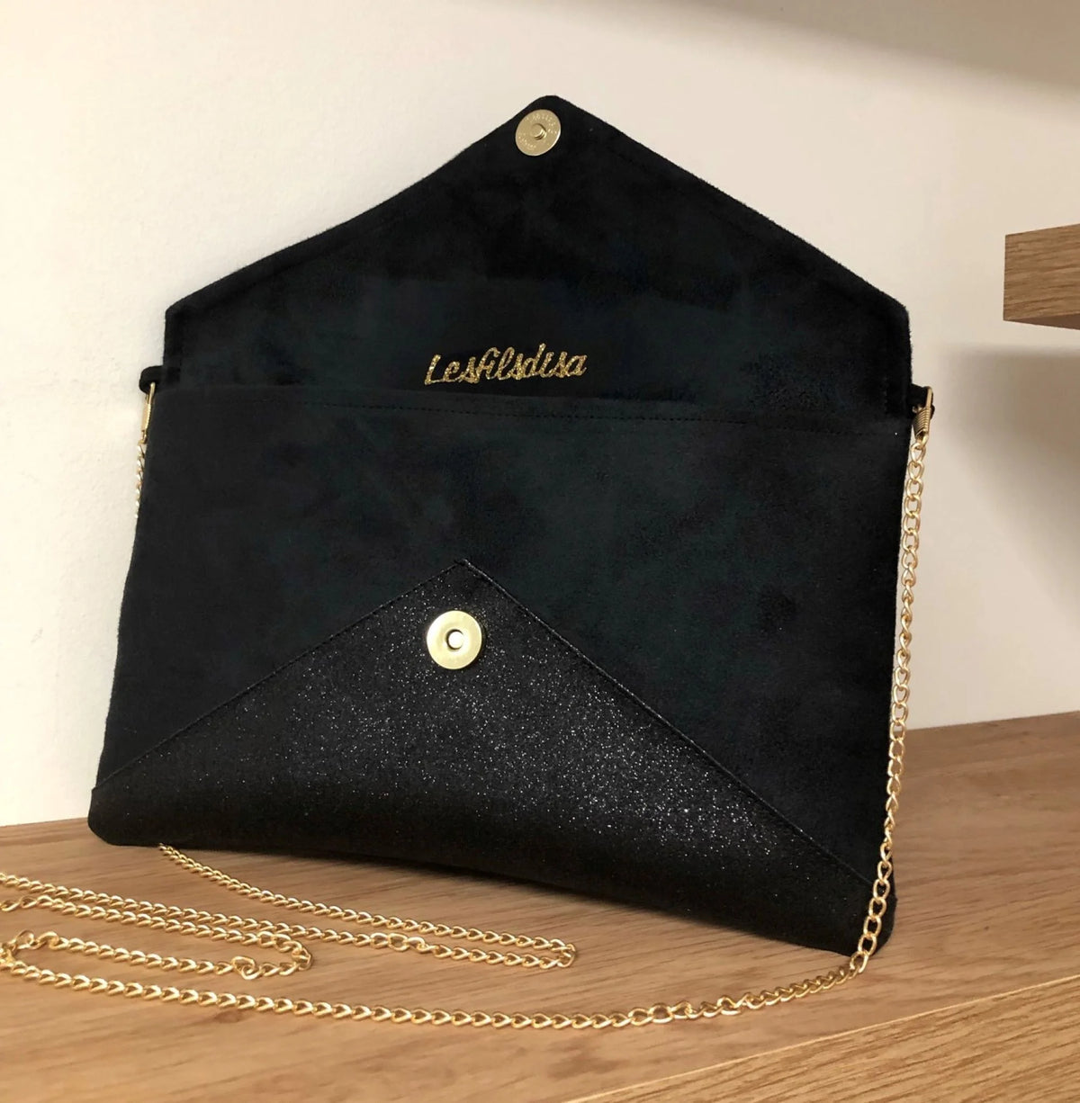Le sac pochette Isa noir à paillettes noires ouvert, avec chainette dorée