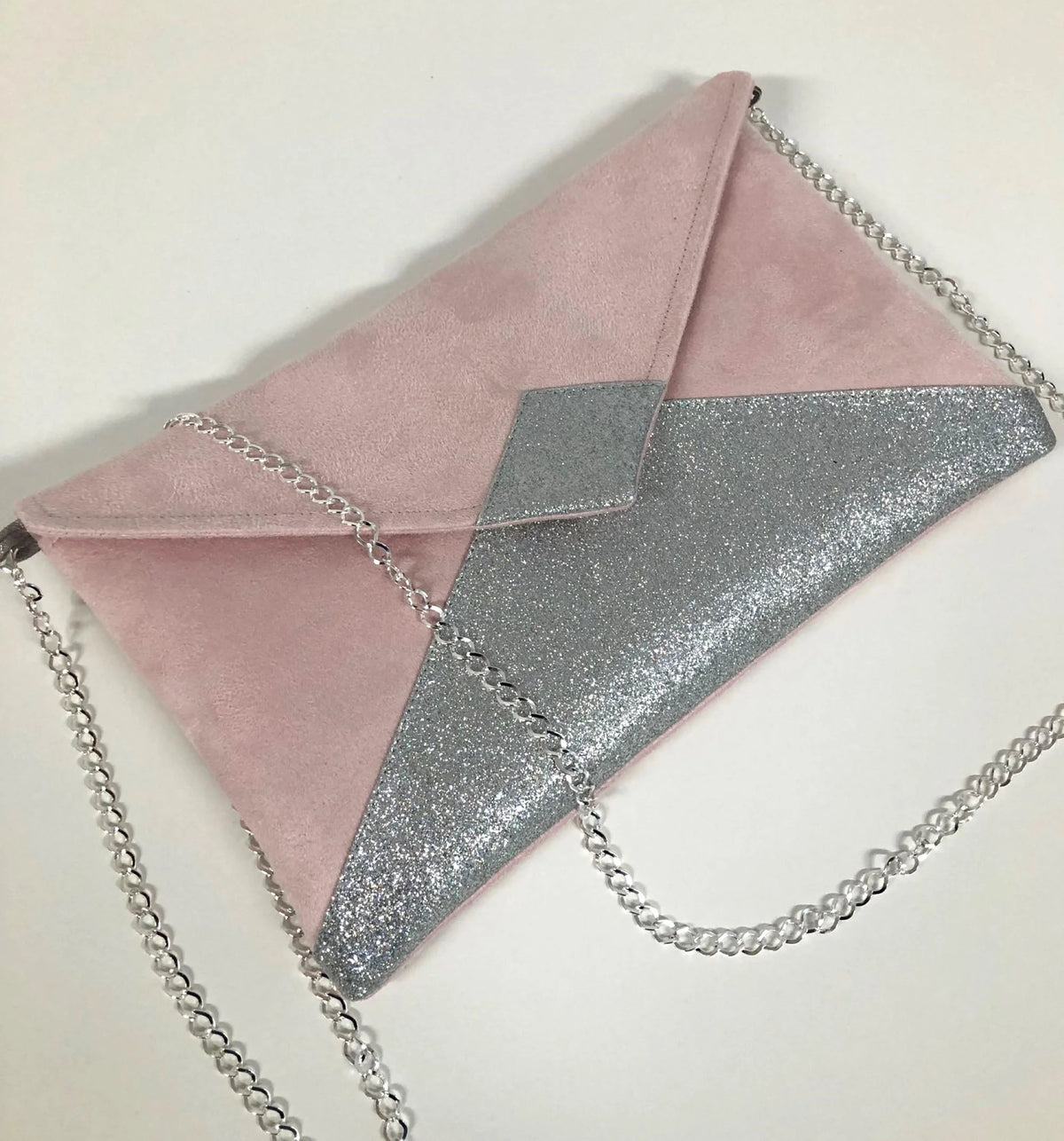 Vue de face du sac pochette Isa rose pâle à paillettes argentées.