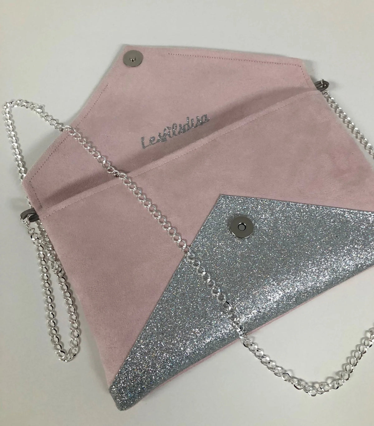 Vue ouverte du sac pochette Isa rose pâle à paillettes argentées.