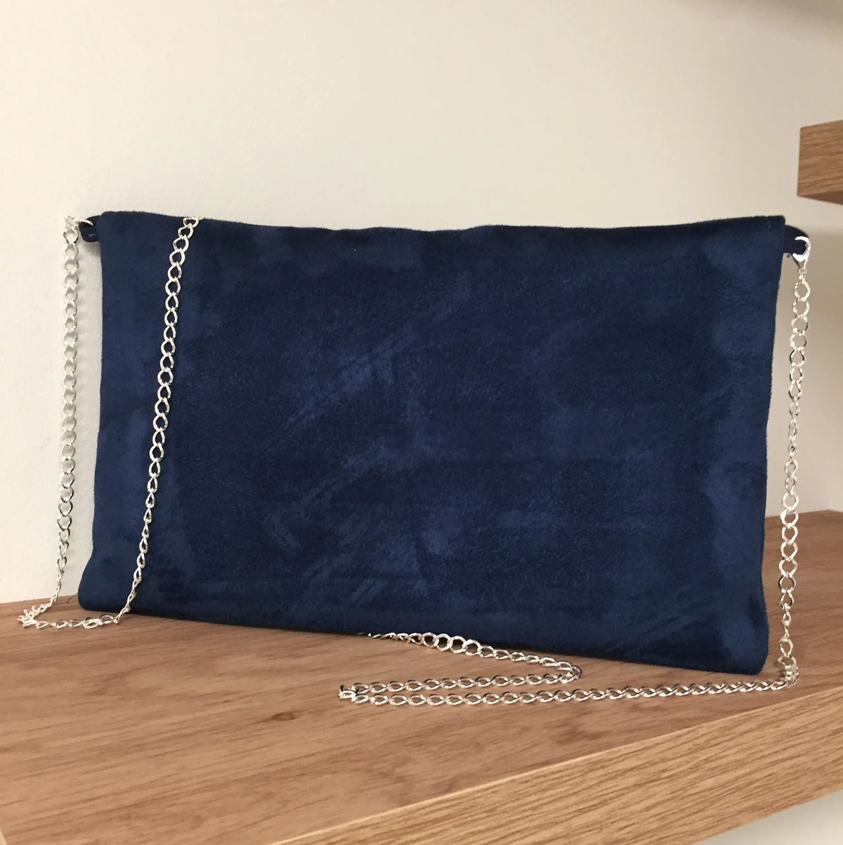 Le dos du sac pochette Isa en suédine bleu marine avec paillettes argentées .