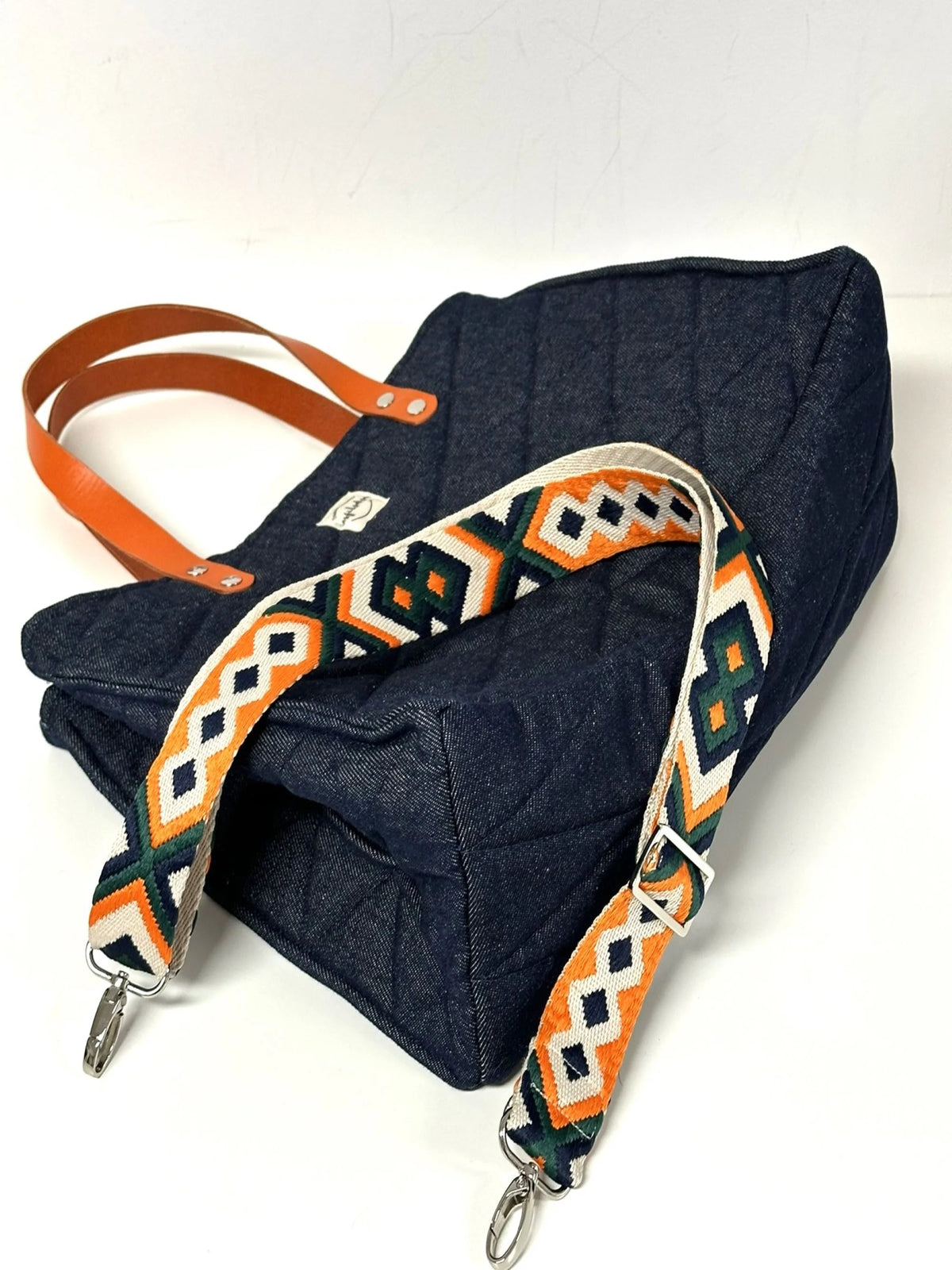 Le fond du sac Shopper en denim et cuir orange.